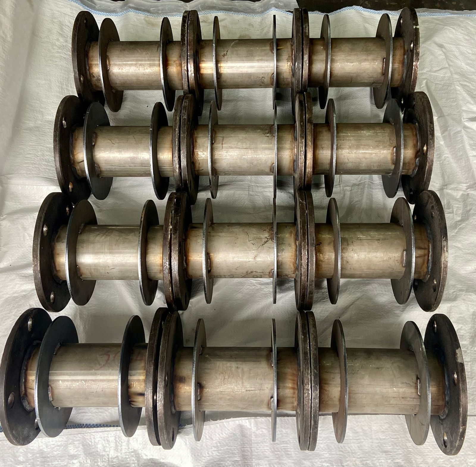 Rows of fabricated pipe spools with weld neck flanges laid out for despatch